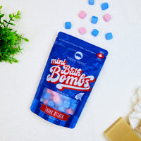 Bag of Shark Attack Mini Bath Bombs on a white background with mini bath bombs scattered around it