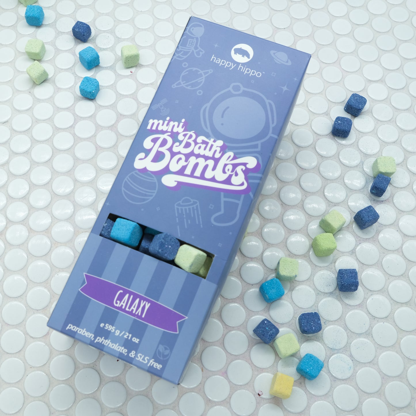 Blue Box of Galaxy Mini Bath Bombs on a white background with bath bombs scattered around it