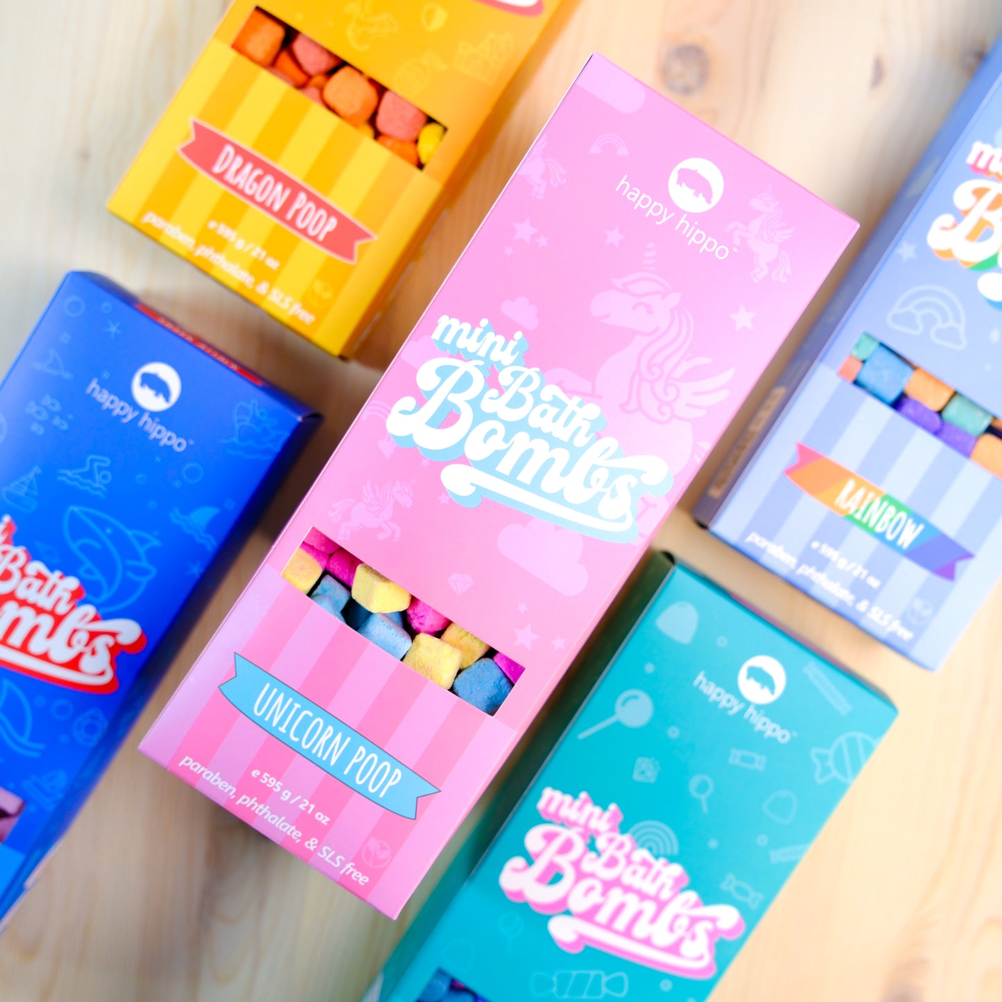 Colorful boxes of 'mini Bath Bombs' with branding on a wooden surface