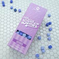 Purple box of Lavender Mini Bath Bombs on a white background with bath bombs scattered around it