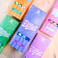 Colorful boxes of mini bath bombs on a wooden surface