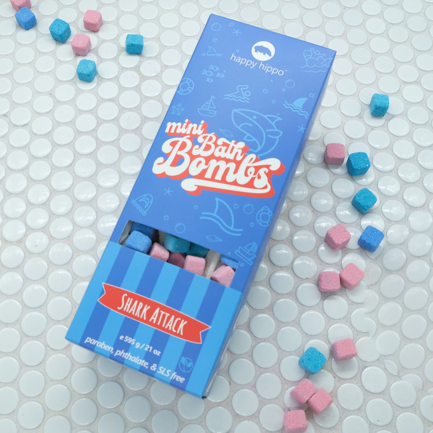 Blue box of Shark Attack Mini bath bombs on a white background with mini bath bombs scattered around it