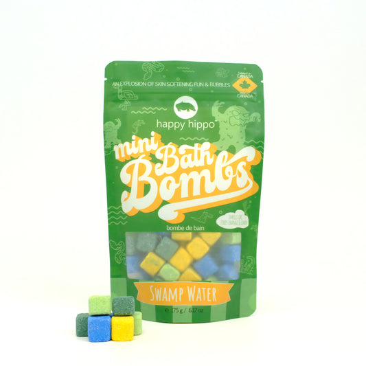 Bag of green Swamp Water Mini Bath Bombs on a white background with mini bath bombs stacked in front of it
