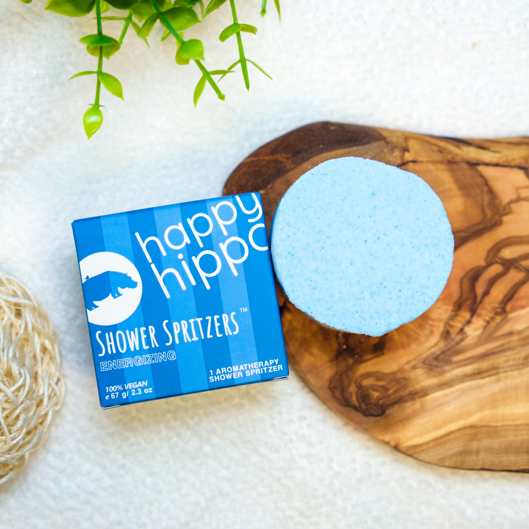 Happy Hippo Shower Spritzer packaging with a blue spritzer on a wooden surface
