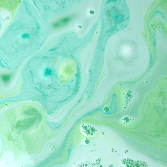 Coldbuster Mini Bath Bombs reacting in the water leaving a green and white colored water